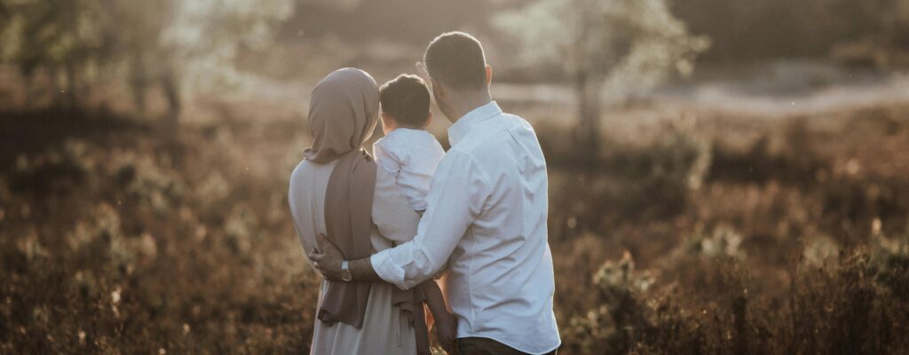 A Muslim family embraces in a scenic field during sunset in Kalmthout, Belgium.