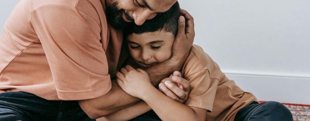 Heartwarming moment of father and son hugging while reading a book together, showcasing love.